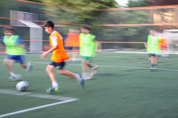 teens boys plays football at a sports school .Blur
