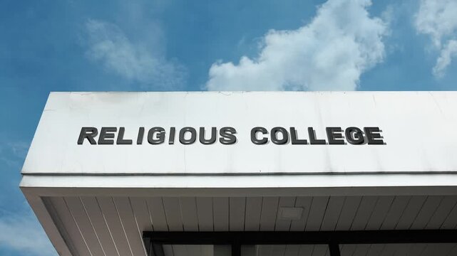 A Religious College word sign displayed on an academic or church building under a clear blue sky, symbolizing theological education, spiritual learning, higher education, and faith-based community