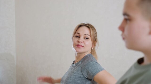 woman and boy doing sideways arm stretch with gym coach instruction focusing on fitness flexibility posture and strength indoors showing teamwork motivation energy