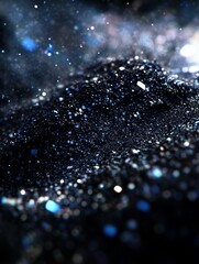 Mesmerizing macro shot of shimmering blue and silver glitter particles on a dark background, resembling a starry night sky or cosmic dust
