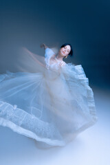 Fototapeta premium Wide twirl in embellished gown, poised arm line and airy motion blur. Concept of luxury fashion visuals, modern decor, and mindfulness through elegant movement.