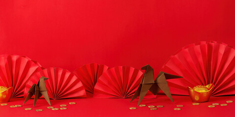 Chinese New Year Decor. Origami animals and gold coins on a vibrant red background.