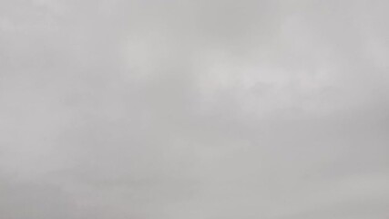 Fast motion time-lapse of dense, heavy clouds or abstract gray smoke swirling and passing quickly across a misty, overcast sky - Powered by Adobe