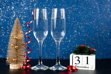 Elegant setup with champagne glasses, mini Christmas tree, and calendar showing December 31.Perfect for year-end events and festive promotions. 