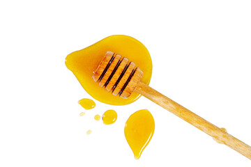 Honey puddle with wooden honey spoon isolated on white.