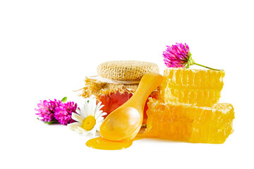 Jar with honey, honeycomb, clover and chamomile flowers and wooden spoon for honey.