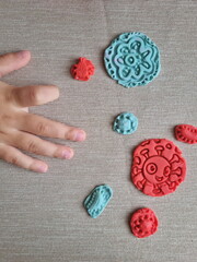 Covid and other respiratory virus molecules made of plasticine. Little toddler education moment in a playful mode. Bacteria made of playdough and kids' hands over the table. 