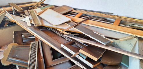 A pile of broken furniture. Dismantling wooden furniture before renovation. Panorama.