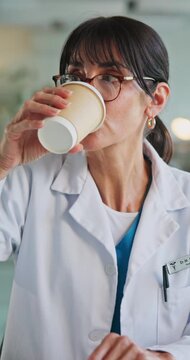 Woman, doctor and writing notes in hospital for prescription, medical record and referral letter. Female person, drinking coffee and diagnosis form, treatment progress and patient chart for discharge