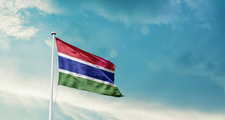 The Gambia national flag fluttering. The flag blowing in beautiful soft sky. The Gambia national flag for independence day.