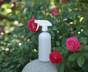 Spray Bottle on Stone Table with Roses Bush