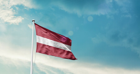 Latvia national flag fluttering. The flag blowing in beautiful soft sky. Latvia national flag for independence day.