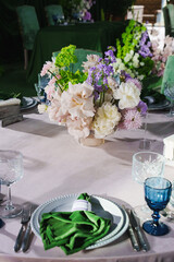 Elegant dining setup with flowers and glassware at event