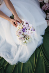 Bridal bouquet held by a bride in a flowing gown