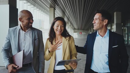 Business people meeting in a business park - Corporate businessmen and businesswoman bonding outdoors, colleagues meeting after work. - Powered by Adobe