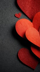 Obraz premium Red paper hearts arranged on a dark background for romance and love stock image