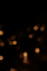 Golden blurred bokeh lights on black background. Glitter sparkle stars for celebrate. Overlay for your design. Bokeh effect golden light background. Golden Christmas concept. yellow sparkling bokeh