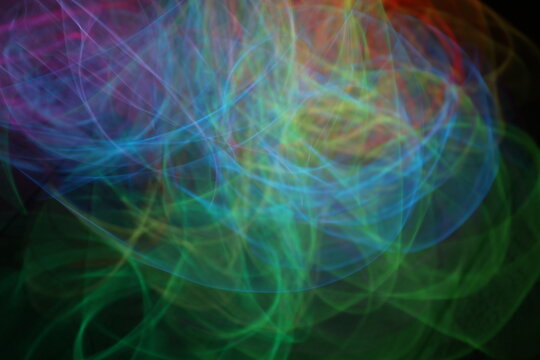 Colorful Neon Light Loops on Dark Background – Abstract Glowing Circles, Red Green Yellow Blue Light Trails, Futuristic Vivid Motion Blur Texture