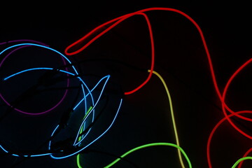 Colorful Neon Light Loops on Dark Background – Abstract Glowing Circles, Red Green Yellow Blue Light Trails, Futuristic Vivid Motion Blur Texture