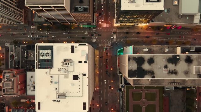 Stunning top drone view in warm colours of building rooftops, modern downtown skyscrapers, busy traffic, crossroads in evening Toronto, Ontario, Canada.