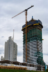 Modern Skyscraper Construction with Crane and Contemporary Architecture under Cloudy Sky