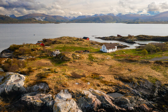 One house on the mountain surrounded by a fjord