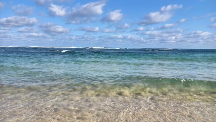 Clear tropical ocean with visible seabed and distant waves