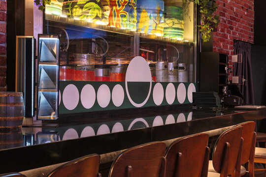 Modern bar counter with beer kegs and colorful decor