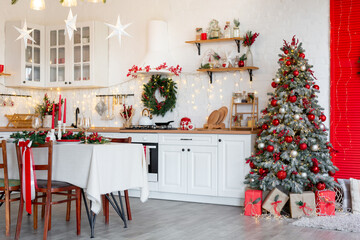 Cozy Christmas kitchen interior with decorated tree, table, candles, and festive garland