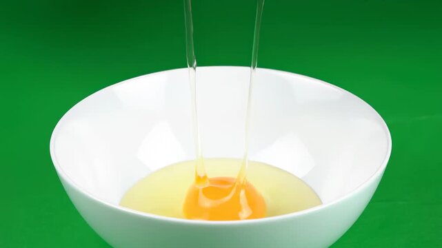 Female Hands Cracking a Fresh Brown Egg into a White Bowl.