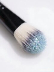 A makeup brush with soft bristles dipped in shimmering ocean pigment