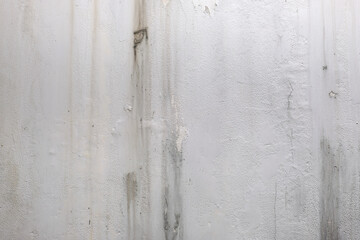 Close-up texture of a damaged white wall with cracked and peeling paint. Perfect for construction, renovation, or interior design backgrounds.