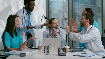 Stressed arguing diverse five people multiethnic group of doctors medical students interns debate...