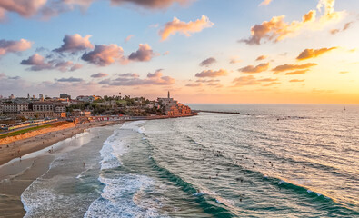 Aerial view of golden light bathing the ancient port city of Old Jaffa, where historic architecture meets the azure sea, Tel Aviv-Yafo, Israel.