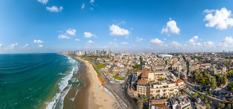 Aerial view of the tranquil turquoise sea meeting the golden sands, contrasting with the modern cityscape of Tel Aviv, Old Jaffa, Tel Aviv-Yafo, Israel.