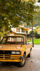 Obraz premium Old Yellow Pickup Truck Parked in an Autumn Village