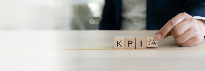 KPI and business performance indicator. Measuring productivity and strategic success. Wooden cube blocks with KPI letters and performance icon. Key performance indicators  and goal management.
