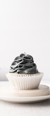 grey frosting on cupcakes with a white background, cupcakes in white liners with tall buttercream swirl, grey buttercream frosted cupcakes on a white background