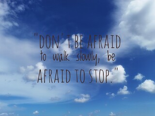 Inspirational blue sky with white clouds and motivational quote Don’t be afraid to walk slowly, be afraid to stop symbolizing perseverance, patience, and hope.