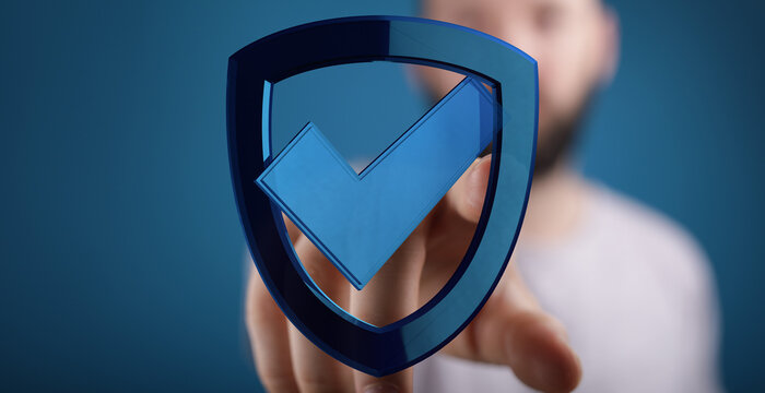 A person pointing to a blue shield icon with a checkmark, representing security, protection, and digital validation.