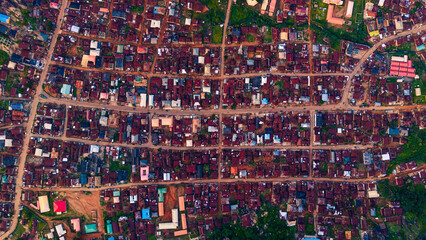 Aerial view of rooftops and roads interweave like threads in a rich tapestry, a mosaic of dwellings under the vast sky, Idanre, Ondo, Nigeria.