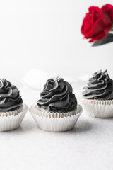 grey frosting on cupcakes with a white background, cupcakes in white liners with tall buttercream swirl, grey buttercream frosted cupcakes on a white background