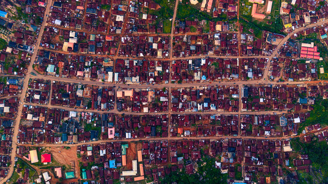 Aerial view of rooftops and roads interweave like threads in a rich tapestry, a mosaic of dwellings under the vast sky, Idanre, Ondo, Nigeria.