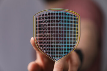 Abstract image of a hand holding a digital shield representing data protection, cybersecurity, and...