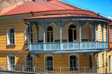 Historic yellow building with a light blue balcony in the center of Tbilisi, Georgia