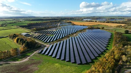 Aerial view of solar panels stretching across the landscape, a symphony of dark rectangles against a backdrop of vibrant green fields, Mansfield, England, United Kingdom.