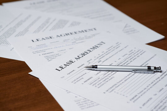 Paper lease agreement forms. Rental agreement paperwork. Document is mock-up