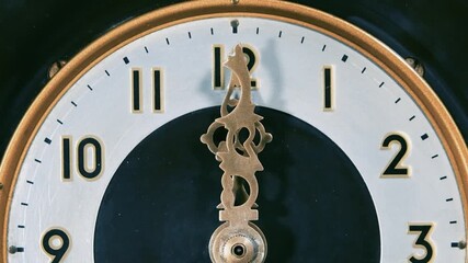 Antique clock, the hand moves towards midnight or noon. Close up