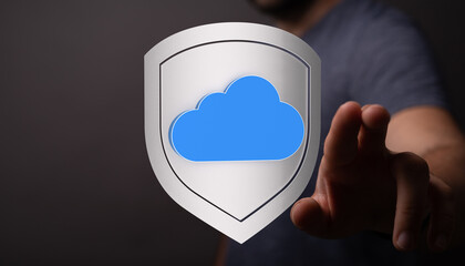 Secure cloud data storage represented by a protective shield and finger touching the cloud symbol. Illustrates concepts of protection