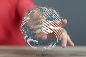 Close-up of a person's hand holding a digitally rendered world globe illustrating global connection...